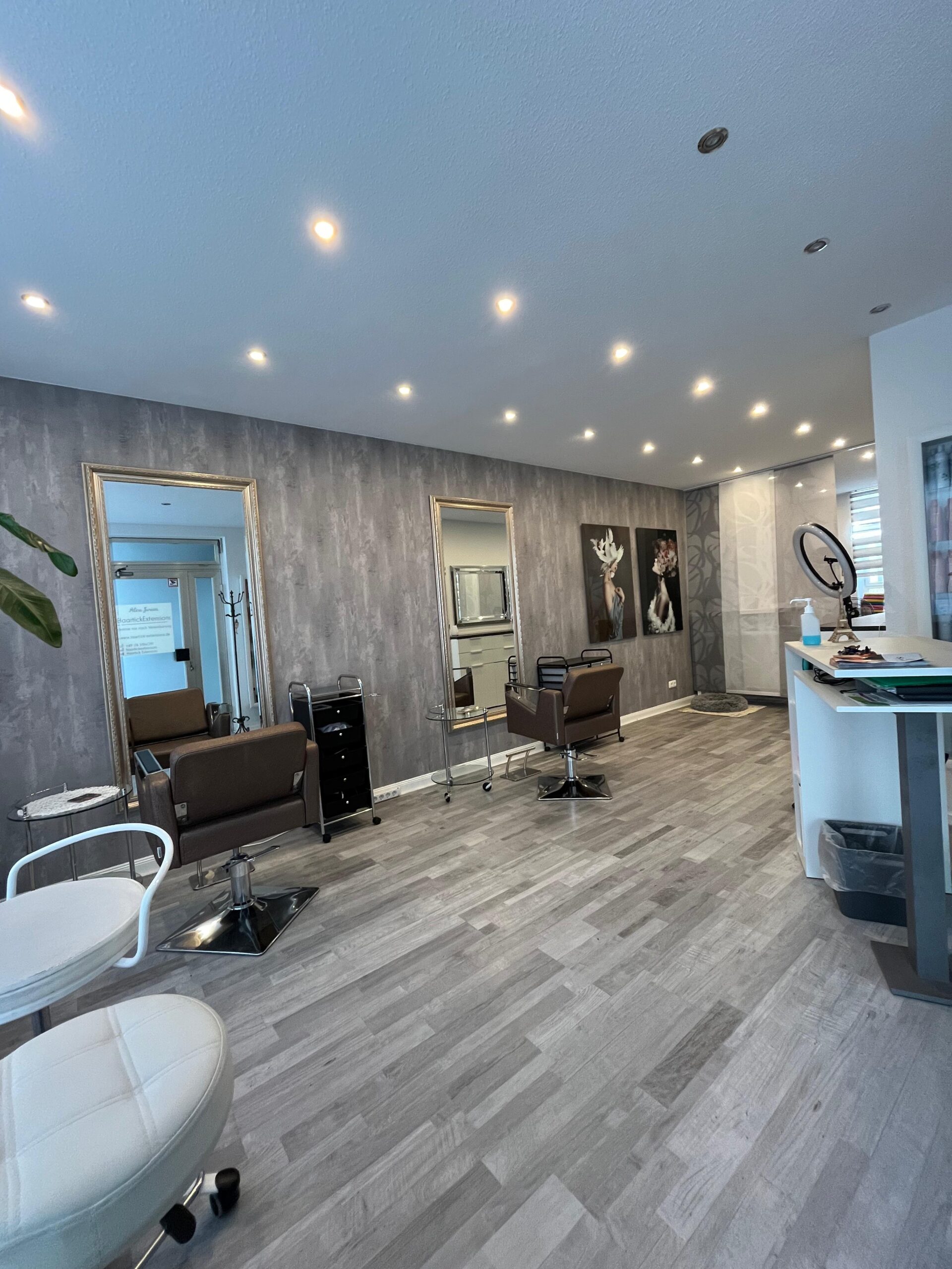 „Moderner Friseursalon mit zwei Stylingplätzen, großen Spiegeln und elegantem Interieur – typische Umgebung für das Einsetzen von Bonding Extensions.“ Wenn du willst, kann ich dir auch einen SEO-optimierten Dateinamen vorschlagen oder eine Bildunterschrift, die inhaltlich zur Seite passt. Sag einfach Bescheid.