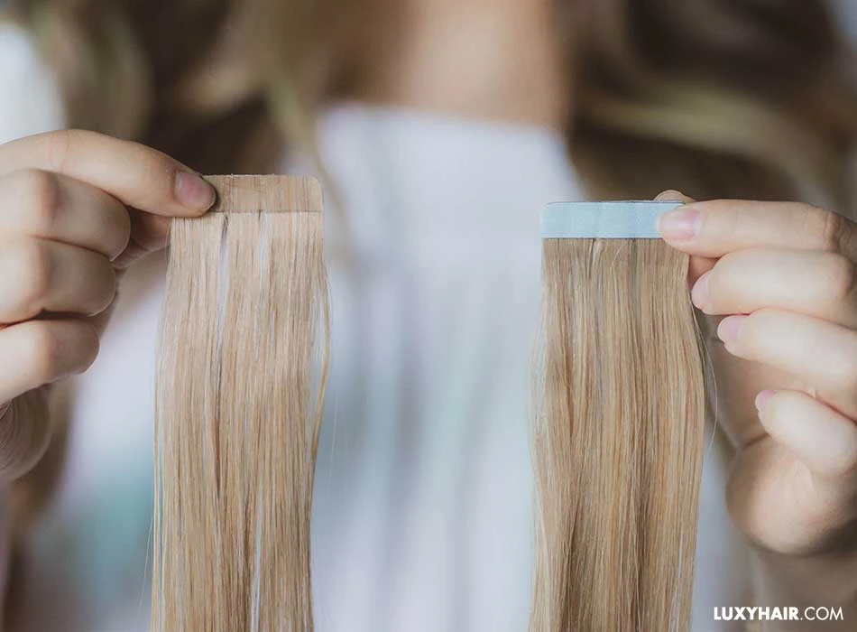 Tape-in Extensions Klebestreifen in Hand gehalten Detailaufnahme