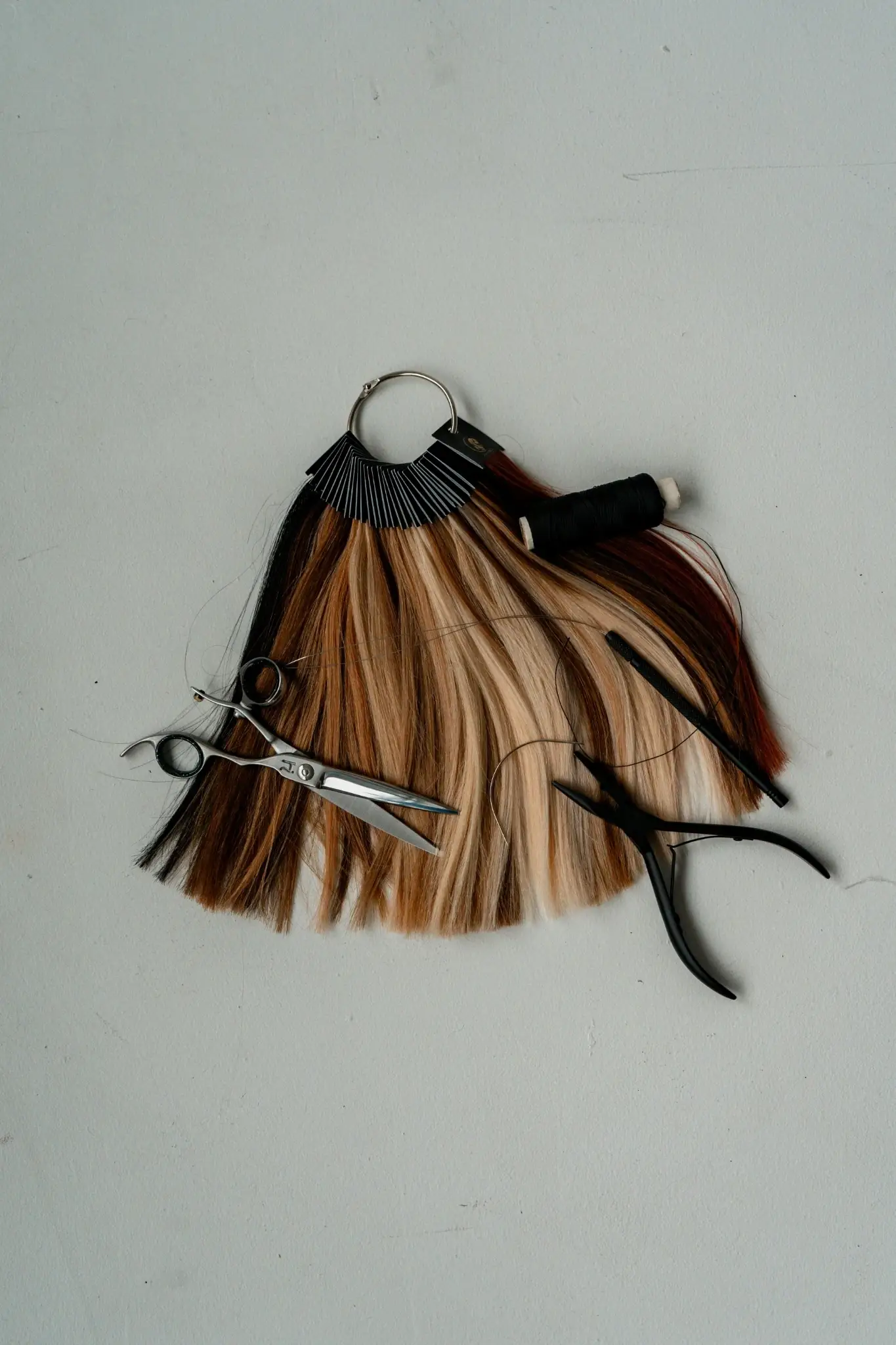 Haar-Extensions Farbmuster mit Schere und Zange für professionelle Verlängerung